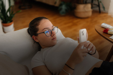 Foto de uma menina concentrada olhando seu celular